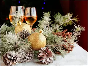 Stroik z szyszkami i bombkami oraz kieliszki z szampanem