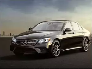 Czarny samochód marki Mercedes na rozmytym tle budynków