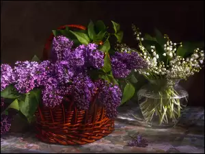 Bukiet bzu w koszu obok konwalii majowej w flakonie