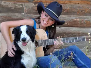 Piosenkarka Carin Mari z gitarą śpiewa dla swojego pupila rasy Border collie