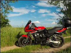 Czerwony motocykl Yamaha FZS600 Fazer na polnej dróżce