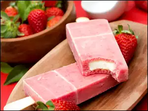 Owocowe lody na patyku i truskawki na tacce