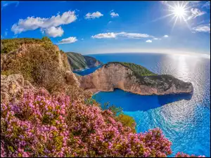 Promienie słońca nad wapiennymi klifami otaczającymi plażę Nawajo na greckiej wyspie Zakinthos