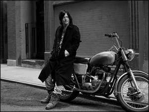 Norman Reedus oparty o motocykl w kadrze B&W
