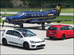 Dwa samochody biały czerwony Volkswagen Golf R360S i samolot