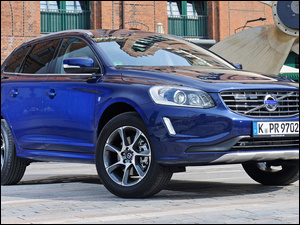 Volvo XC60 niebieskie zaparkowane przed budynkiem