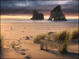 Ciemne chmury nad plażą Wharariki Beach w Nowej Zelandii