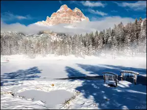 Mostek nad zasypanym śniegiem jeziorem Antorno Lake we włoskich Dolomitach