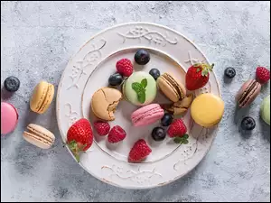 Na talerzu swieże owoce i ciasteczka makaroniki