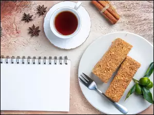 Notatnik obok ciasta i herbaty w filiżance