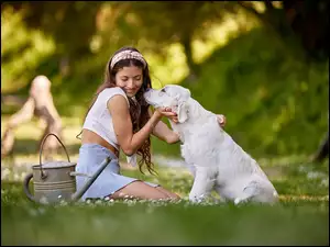 Dziewczyna ze szczeniakiem golden retrievera na łące