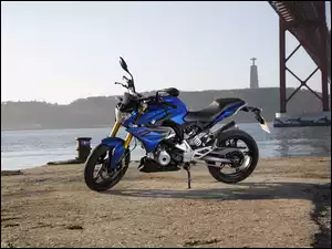 niebieski motocykl BMW z serii G 31O R na nabrzeżu