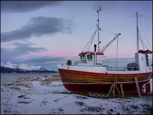 Kuter na zimowym brzegu rzeki w Norwegii