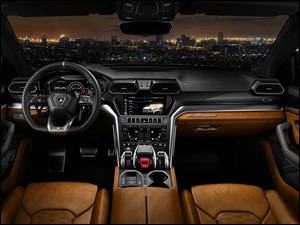 wnętrze samochodu Lamborghini Urus 2018 z widokiem na panoramę miasta nocą