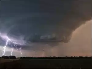 Tornado z piorunami nad polem z wiatrakami