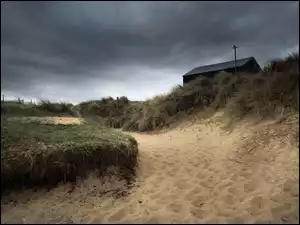 Zachmurzone niebo nad wydmami z szopą