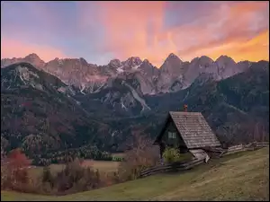 Chata na wzgórzu na tle gór