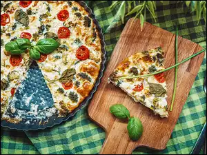 Pizza na tacy obok deski z plasterkiem pizzy