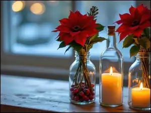 Kwiaty gwiazdy betlejemskiej w szklanych naczyniach i zapalona świeca w butelce przy oknie