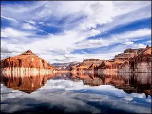 Białe obłoki nad skałami i jeziorem Powell Lake