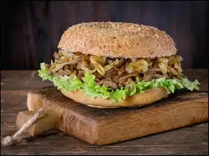 Hamburger z dodatkami przygotowany na desce