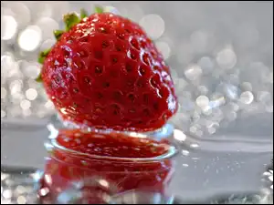 Truskawka w odbiciu na rozmytym tle