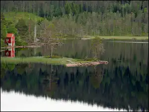 Czerwony domek nad brzegiem jeziora
