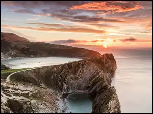 Zatoka Lulworth Cove, Morze, Wschód słońca, Hrabstwo Dorset, Skały, Chmury, Anglia, Wzgórza