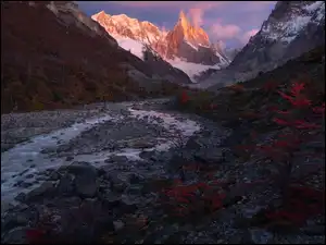 Widok znad rzeki na rozświetlone góry Cerro Torre w Patagonii
