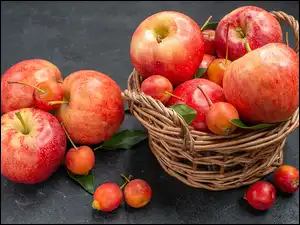 Jabłka w koszu i obok kosza